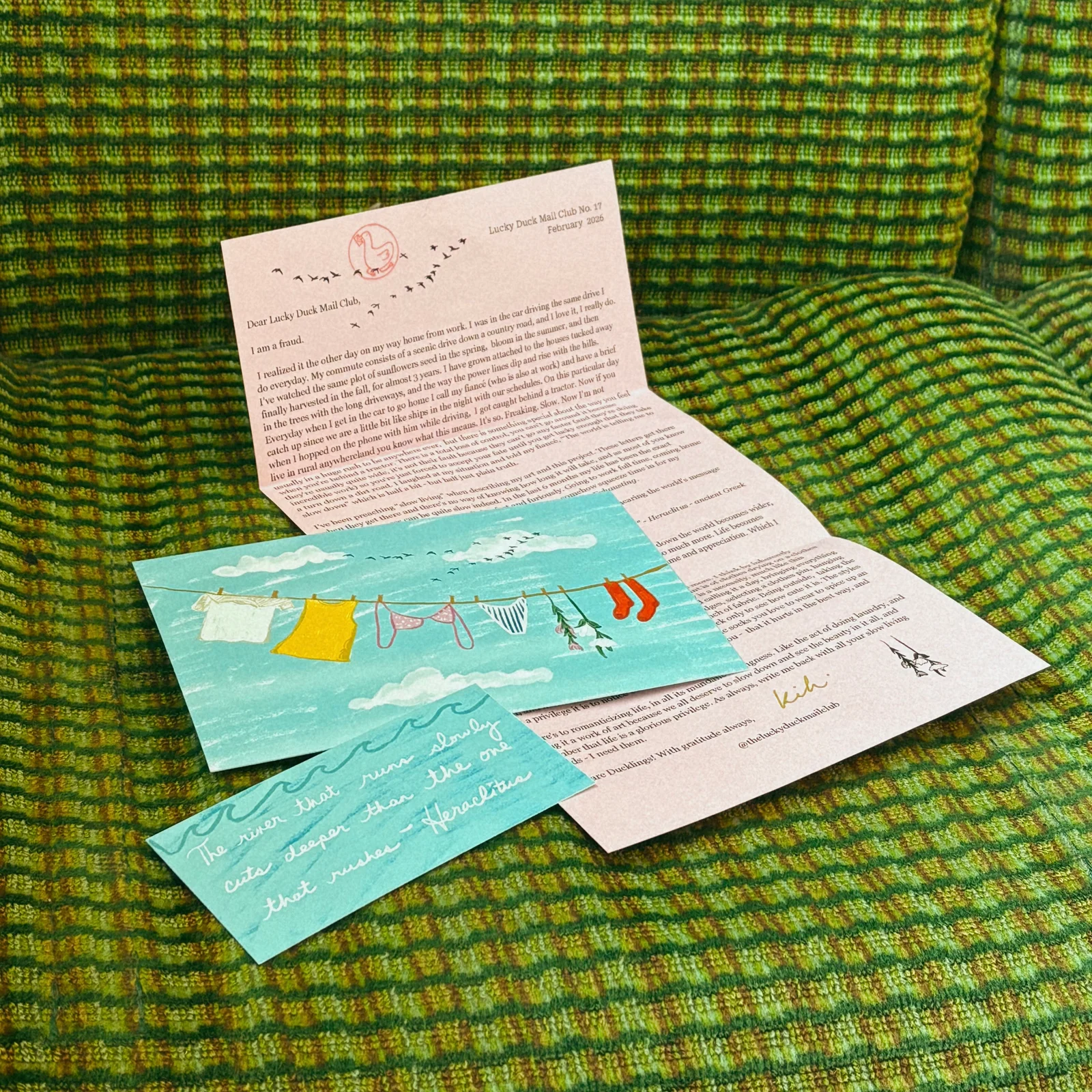 Lucky Duck’s February standard edition: a pink letter, a clothesline illustration and a blue quote card on a green chair.