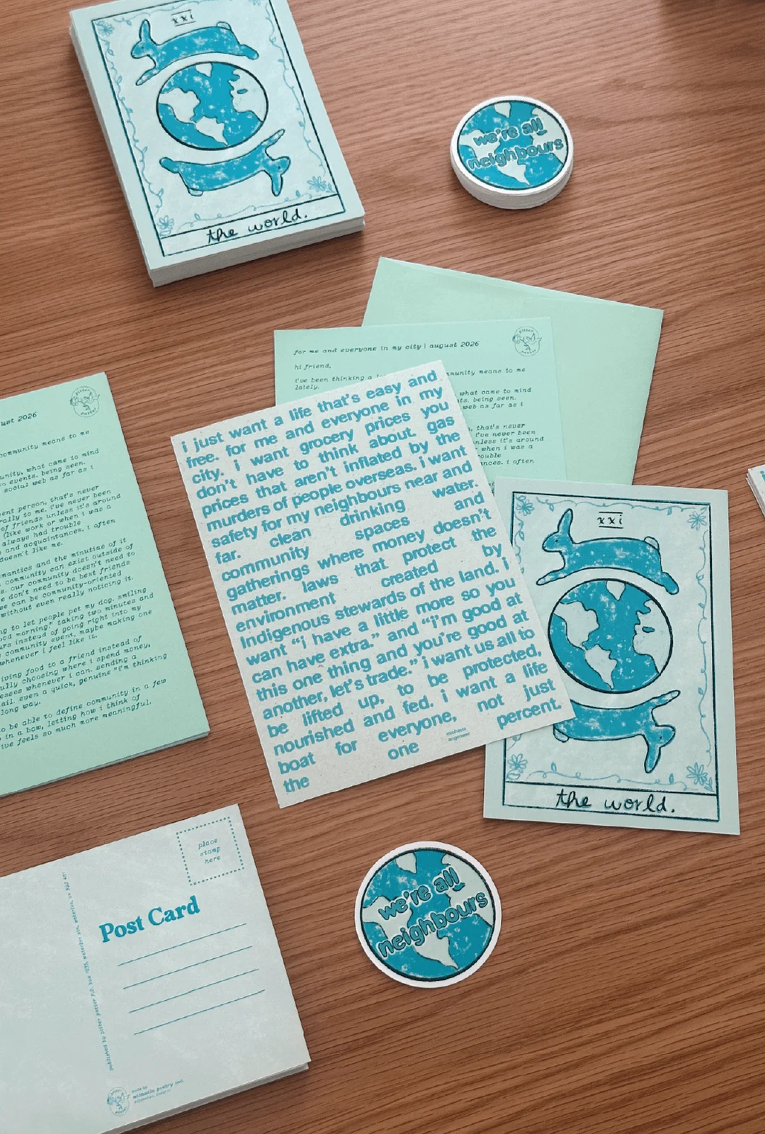 Pitter Patter’s August mail with a turquoise poetry print, letter, globe illustrations and round globe stickers.