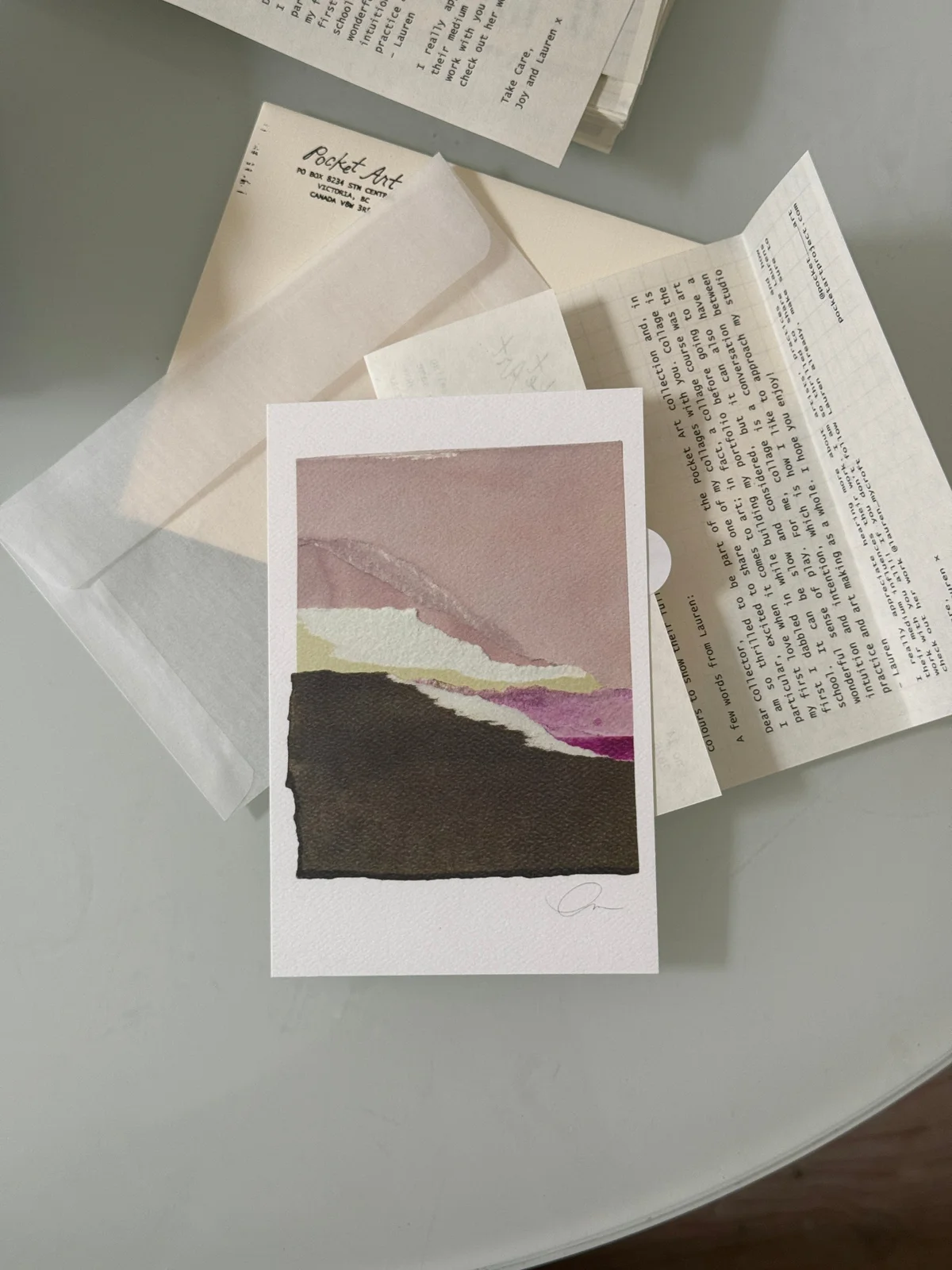 A Pocket Art collage print in mauve, cream and black, arranged with an artist’s note and envelope.