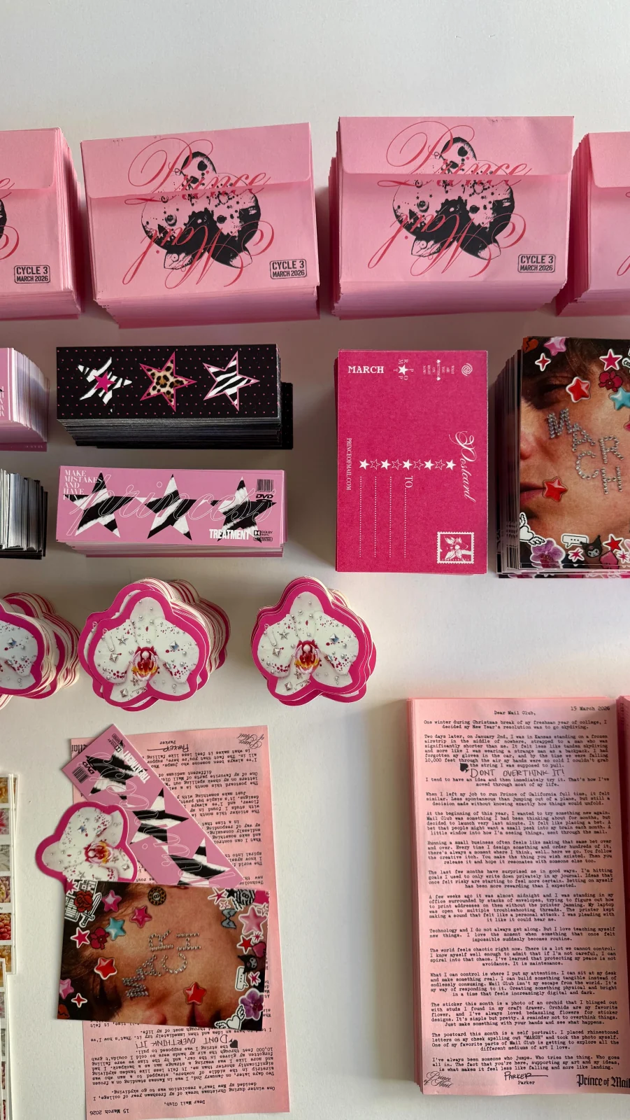 Prince of California’s March mail with pink envelopes, orchid stickers, and photographic postcards
