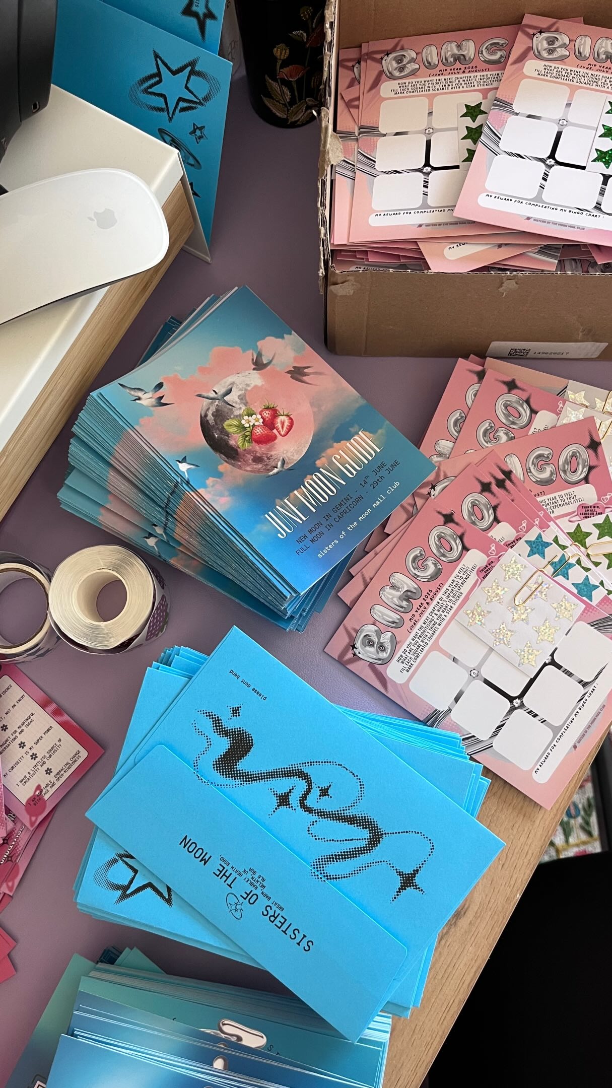 Sisters of the Moon — June moon guides, bingo cards, stickers, and blue envelopes being packed