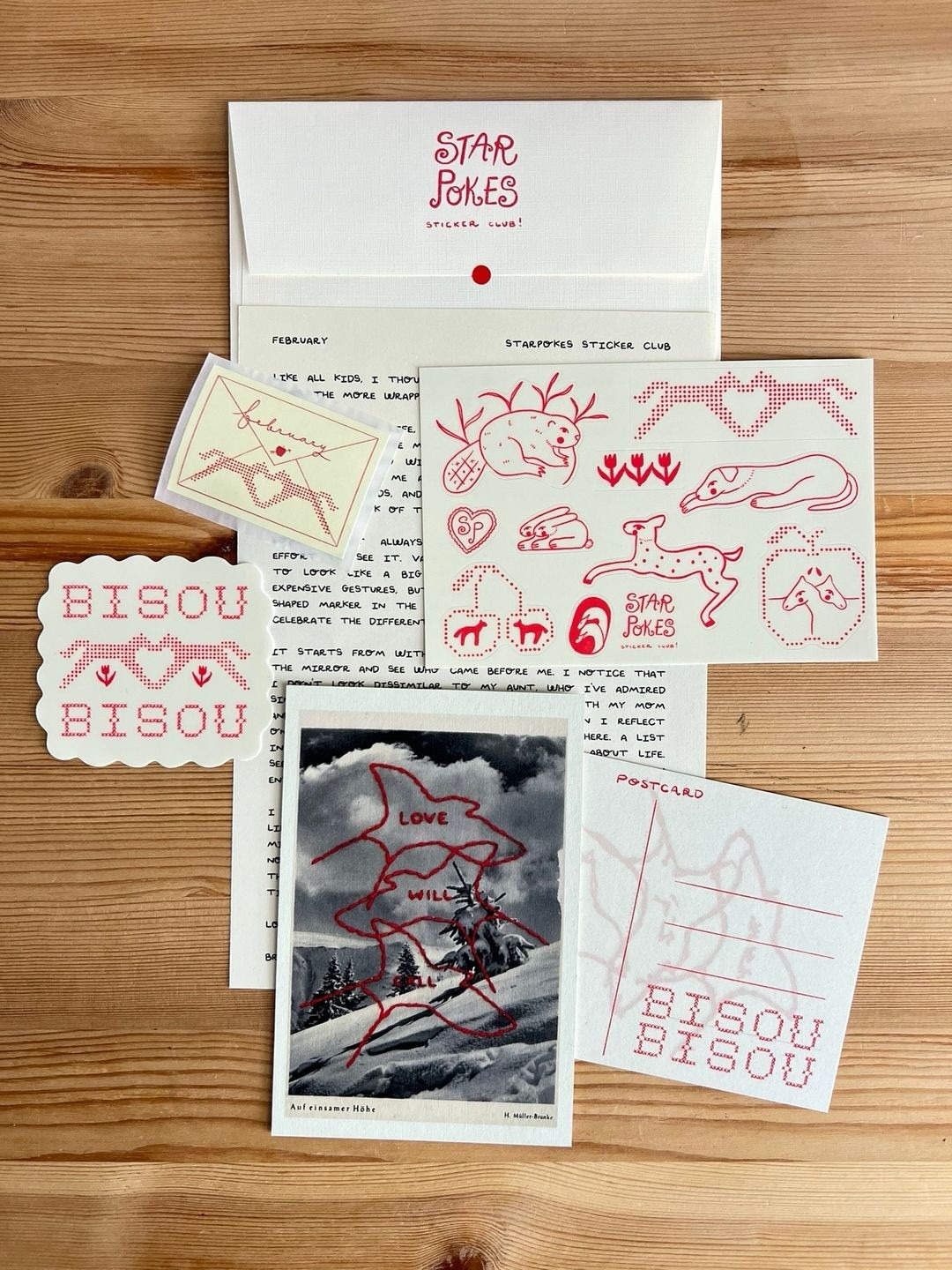 Starpokes February mail laid out with a letter, envelope, red illustrated stickers, sticker sheet and postcard