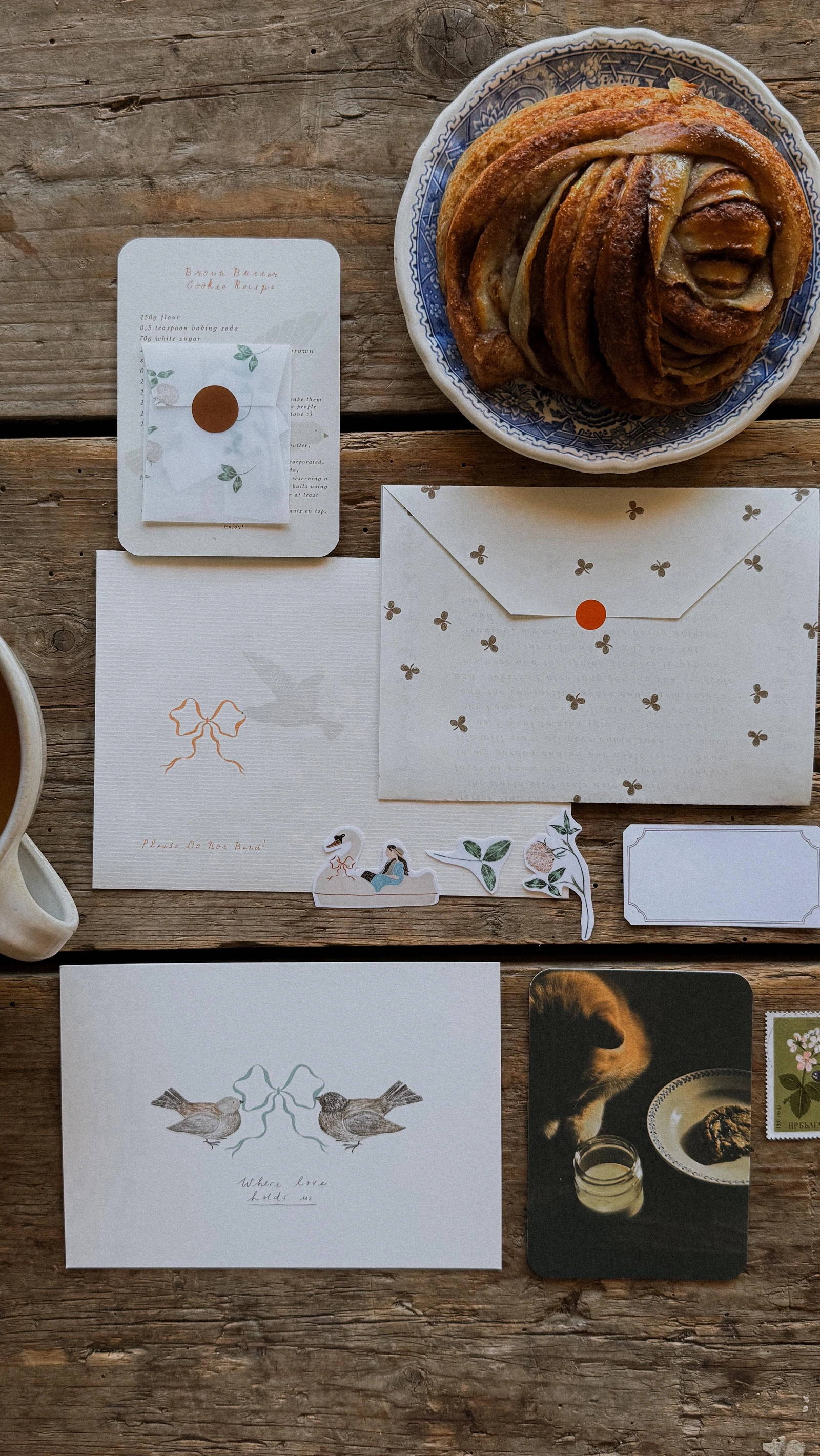Meadow Letters: Bird illustration, recipe, stickers, photograph, and envelope beside a pastry