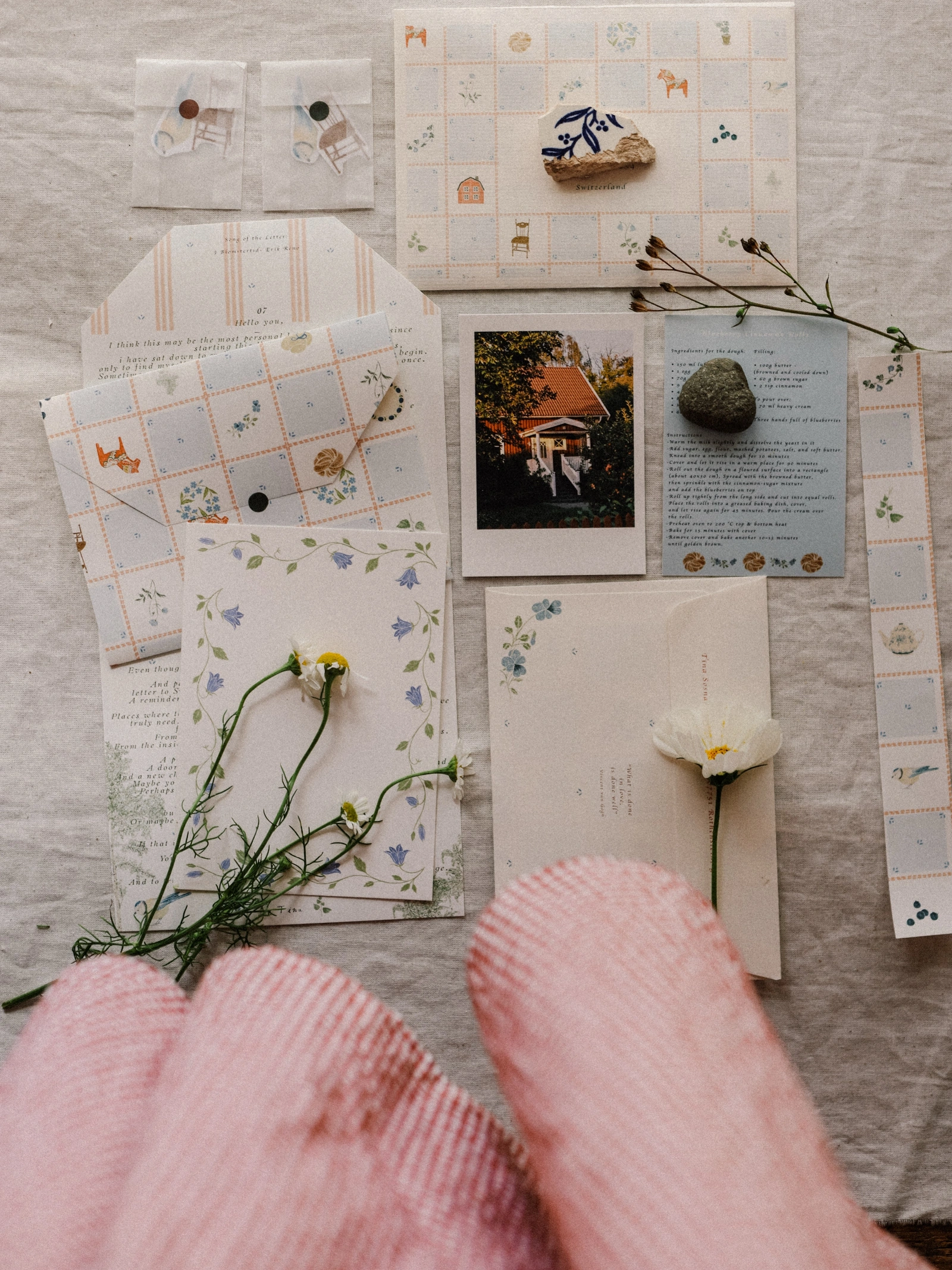 Meadow Letters: Letter, floral stationery, photo card, and recipe arranged on linen with a pink sleeve in the foreground